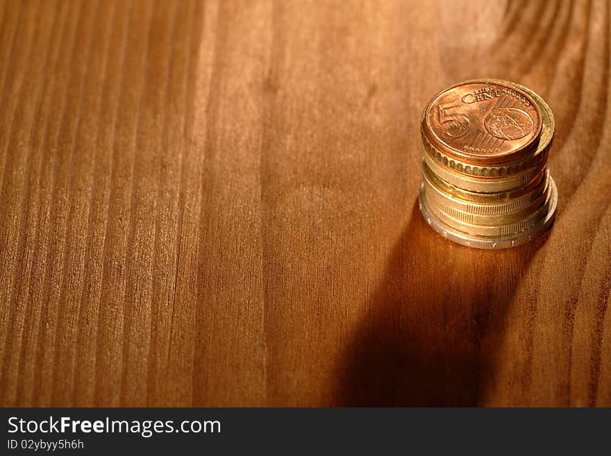 Stack of euro coins on wooden background with copy space