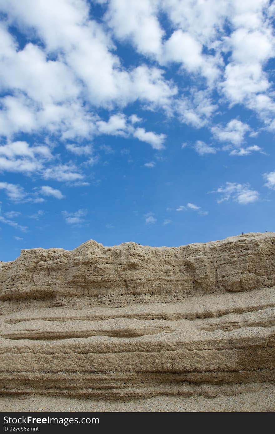 The sand that pile up to is , and have the background is the sky. The sand that pile up to is , and have the background is the sky