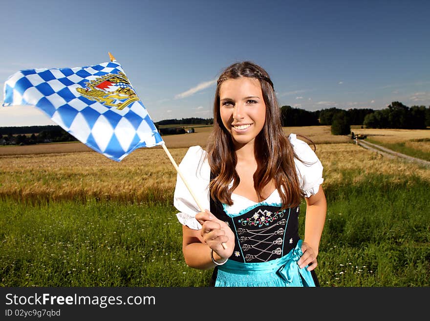 Beautiful bavarian girl in traditional dress with a bavarian flag. Beautiful bavarian girl in traditional dress with a bavarian flag