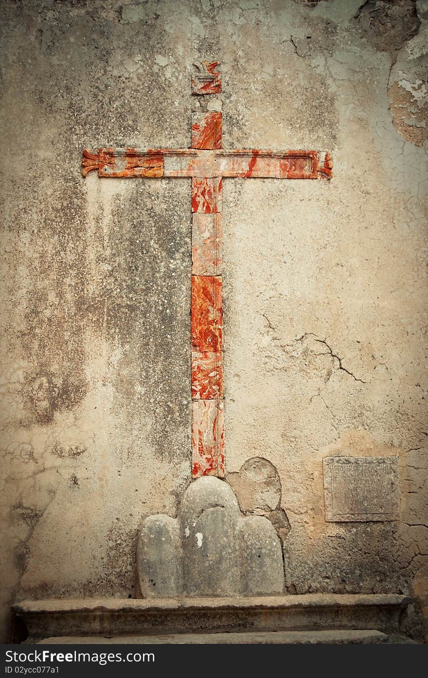 The red sign of the cross on the wall.