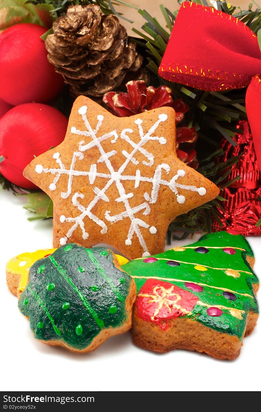 A wide variety of Christmas cookies is against the backdrop of a fragment of a Christmas wreath. All brightly colored cookies. Isolated on white background. A wide variety of Christmas cookies is against the backdrop of a fragment of a Christmas wreath. All brightly colored cookies. Isolated on white background.