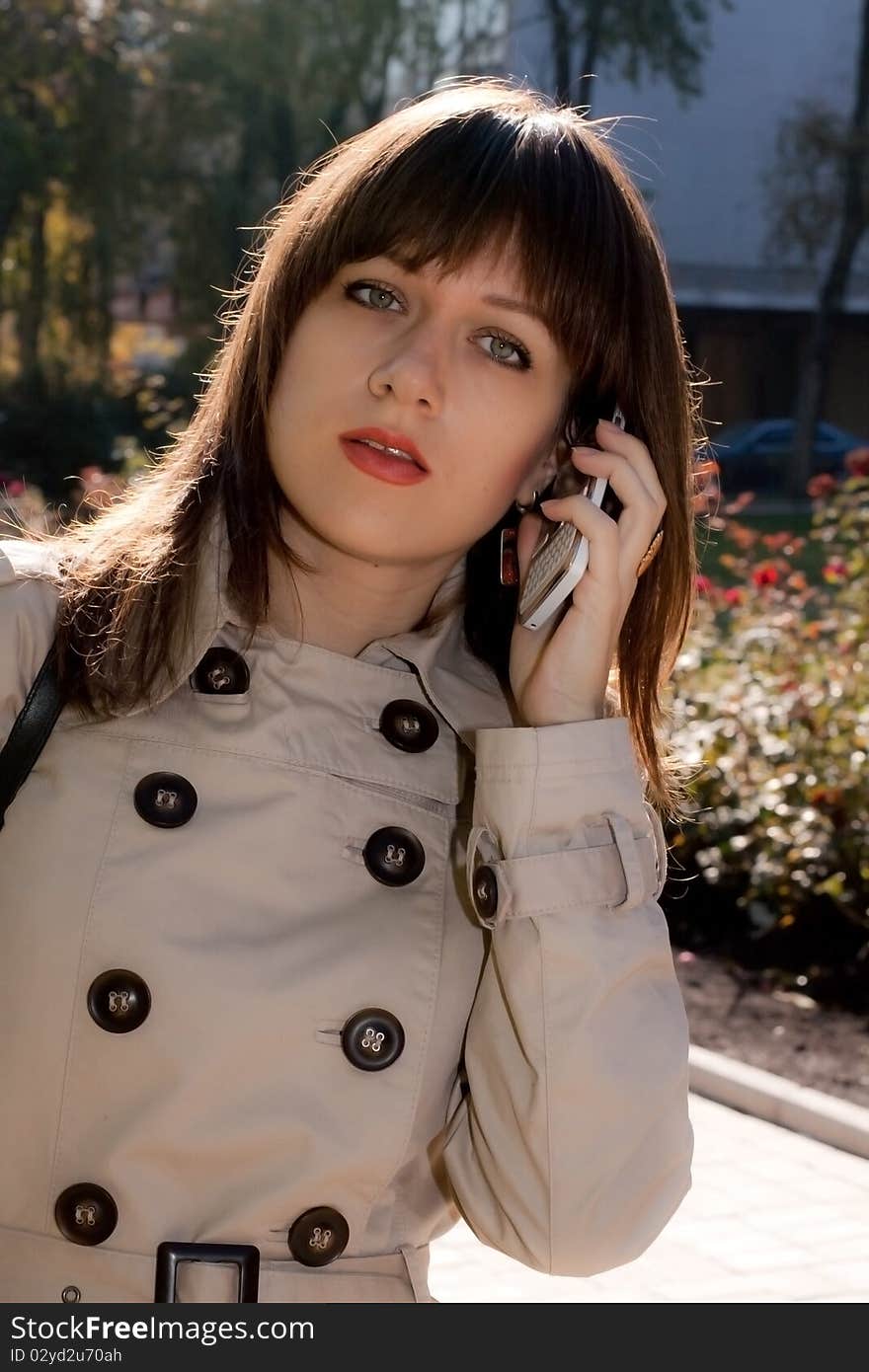 Young beauty business woman with white phone. Young beauty business woman with white phone