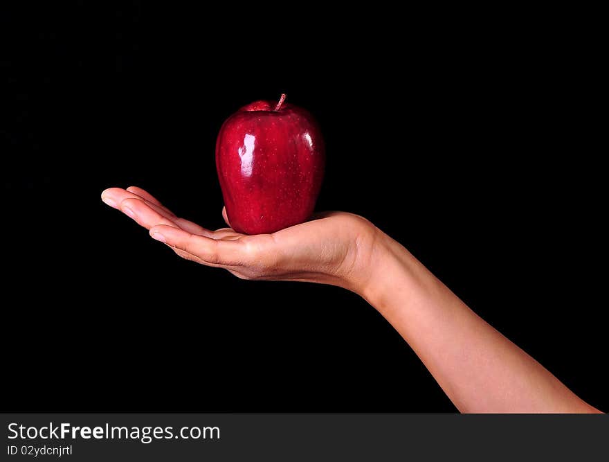 Female hand holding up a red apple