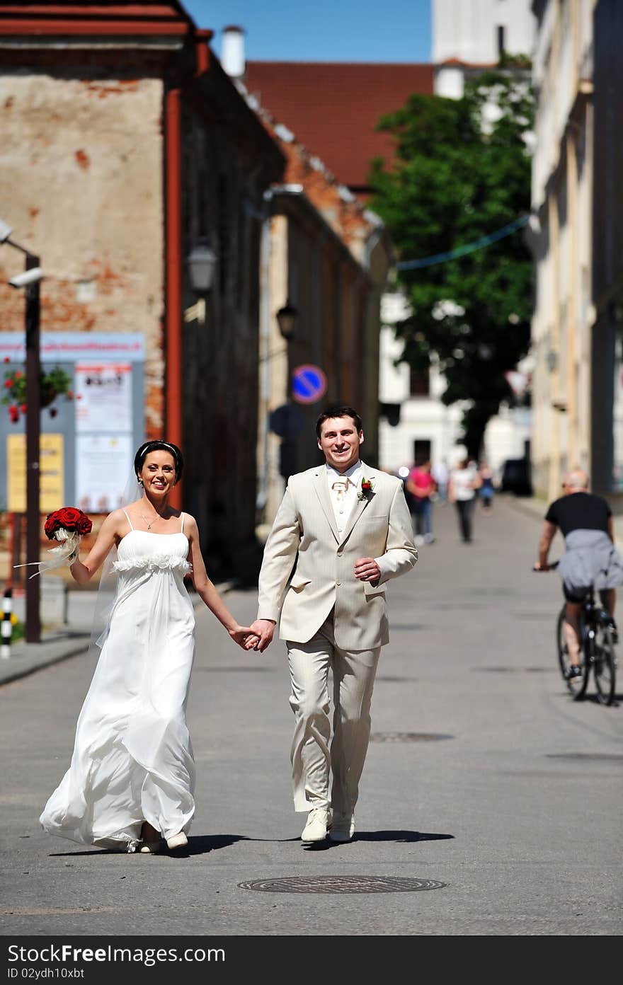 Newly wed couple  run on sidewalk. Newly wed couple  run on sidewalk