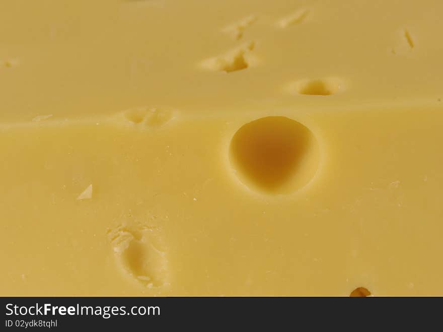 Fragment of yellow cheese and hole