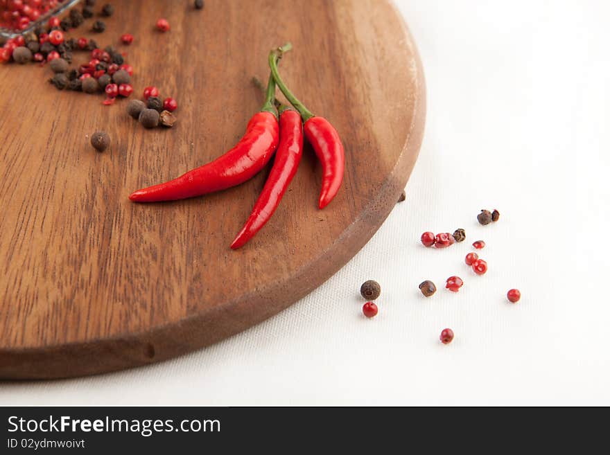 Red chili pepper and pepper's mix on the wooden desk