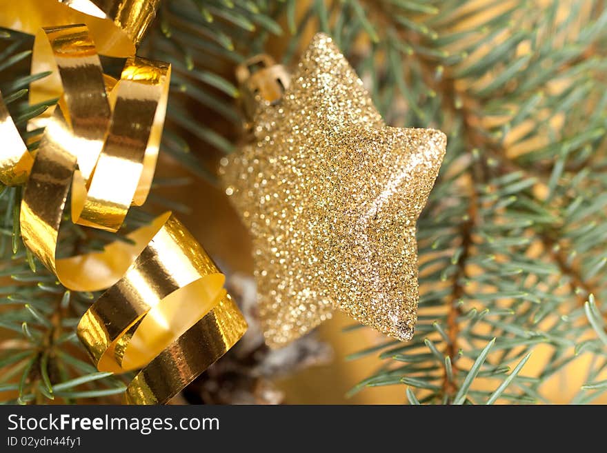 Golden christmas star and tape with christmas tree on the gold background. Golden christmas star and tape with christmas tree on the gold background