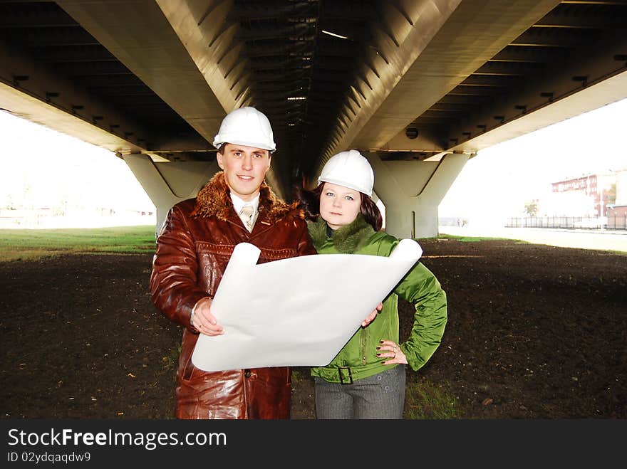 Young architects looking at blueprint.