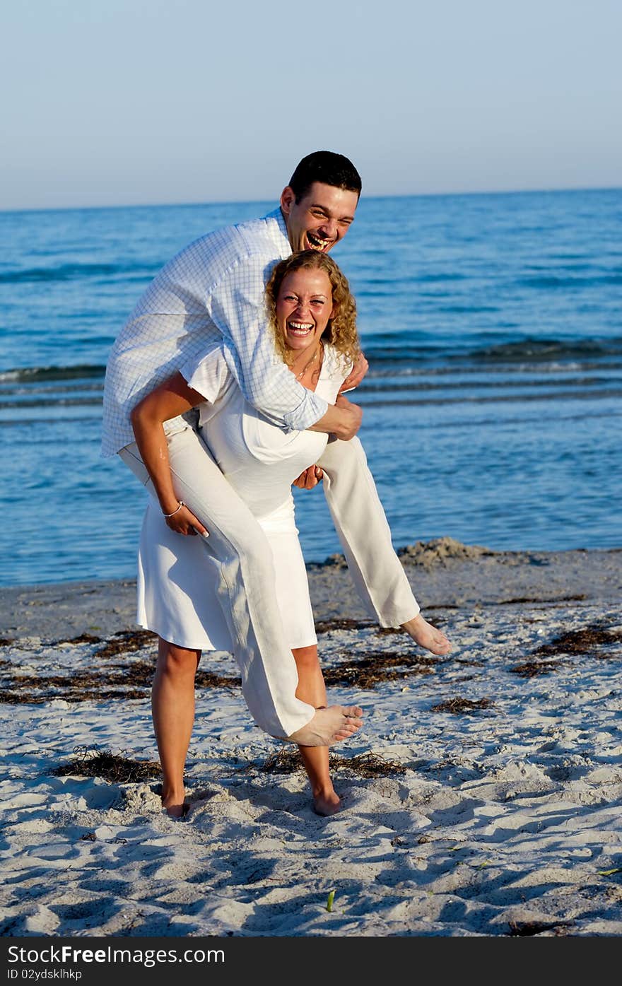 A happy young woman and man having fun on beach. A happy young woman and man having fun on beach.