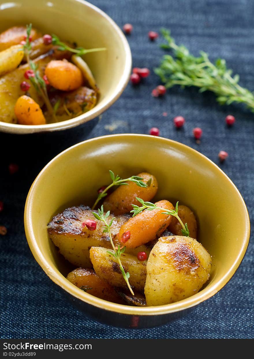 Roasted garlic potatoes and carrots with thyme and pepper. Roasted garlic potatoes and carrots with thyme and pepper