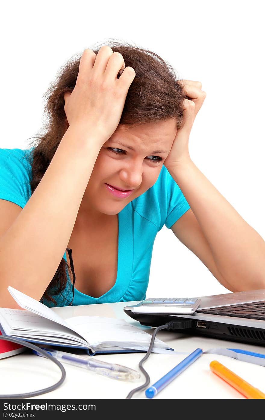 Depressed student holding her head, looking to laptop