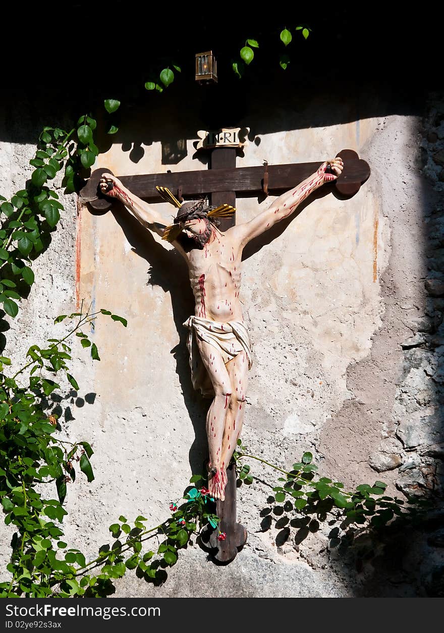 A beautiful wooden crucifix hanging on the wall illuminated by the sun