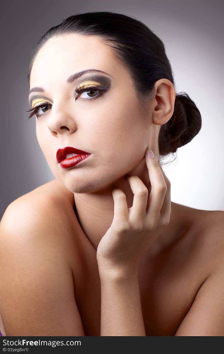 Beautiful woman over grey background with beautiful makeup