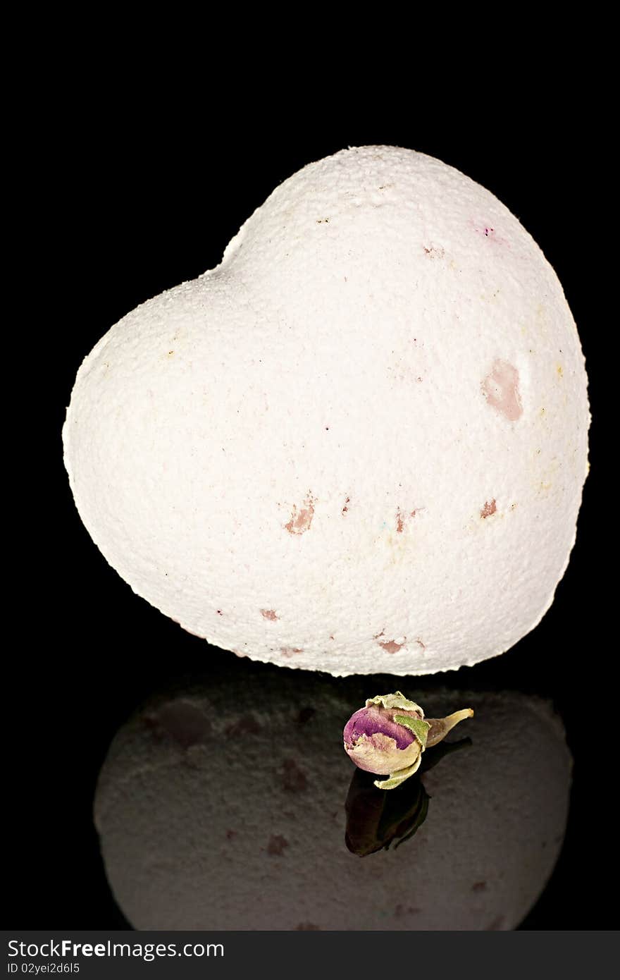 Bath salts in the form of the heart with a dry flowers on a black background. Bath salts in the form of the heart with a dry flowers on a black background.