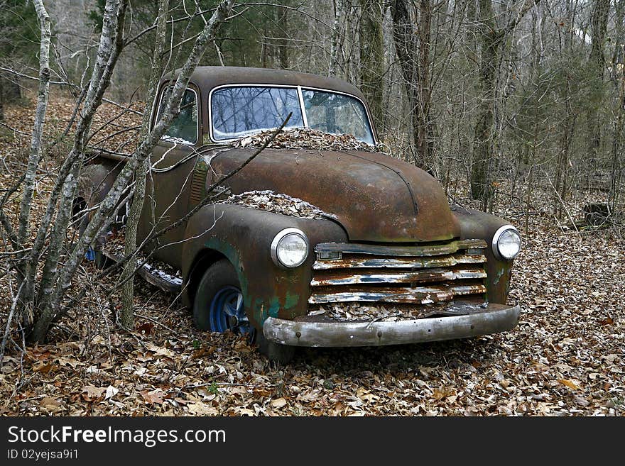 Just off the ebaten path an old pickup truck has been abandonded in the woods. Just off the ebaten path an old pickup truck has been abandonded in the woods