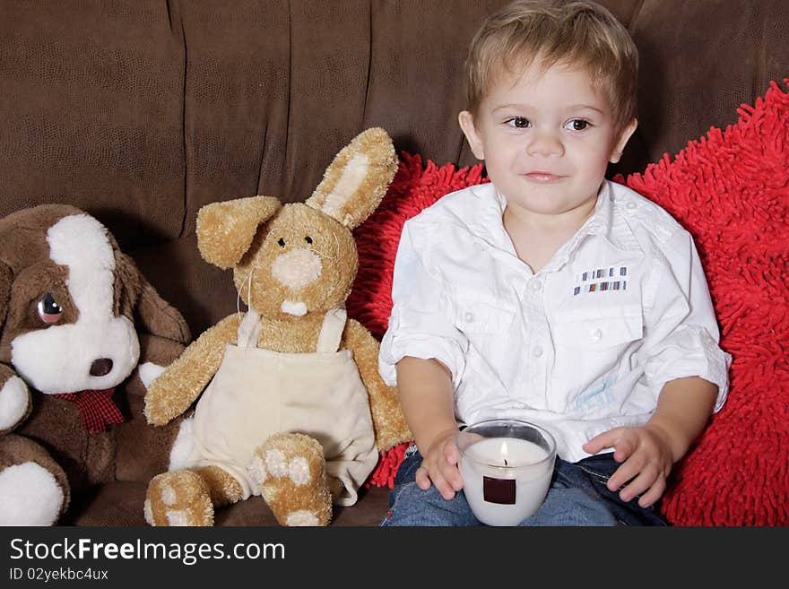 Cute toddler boy sitting on sofa