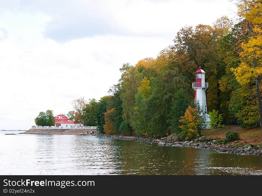 White and red lighthouse on bank of bay