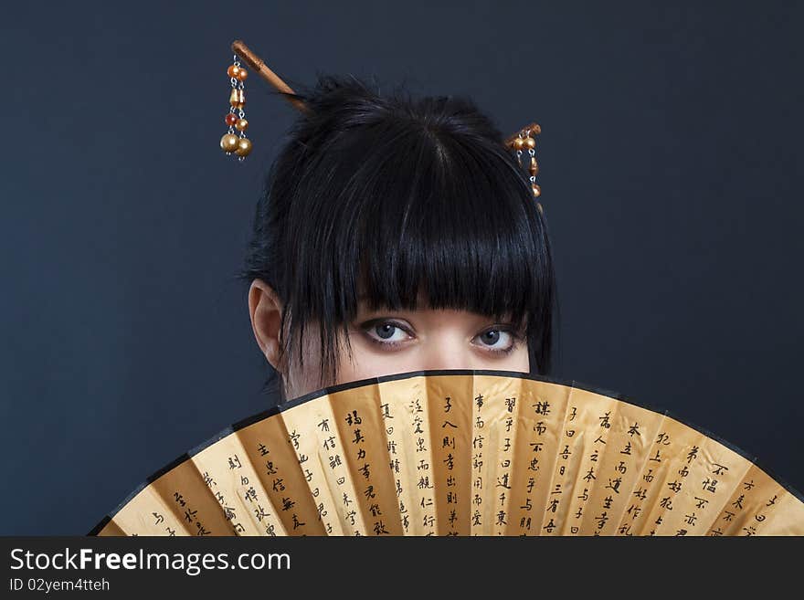 Portrait of girl in geisha costume on black background