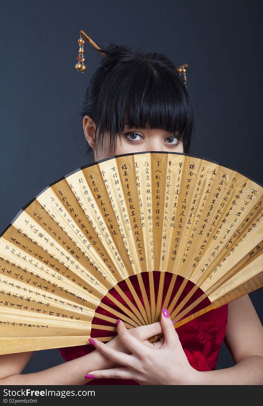 Portrait of girl in geisha costume on black background