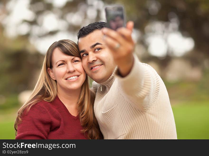 Attractive Mixed Race Couple Taking Self Portraits in the Park.