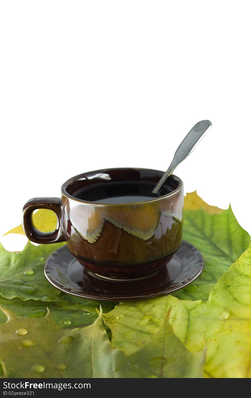 Still-life from a cup of tea and yellow autumn leaves on a white background