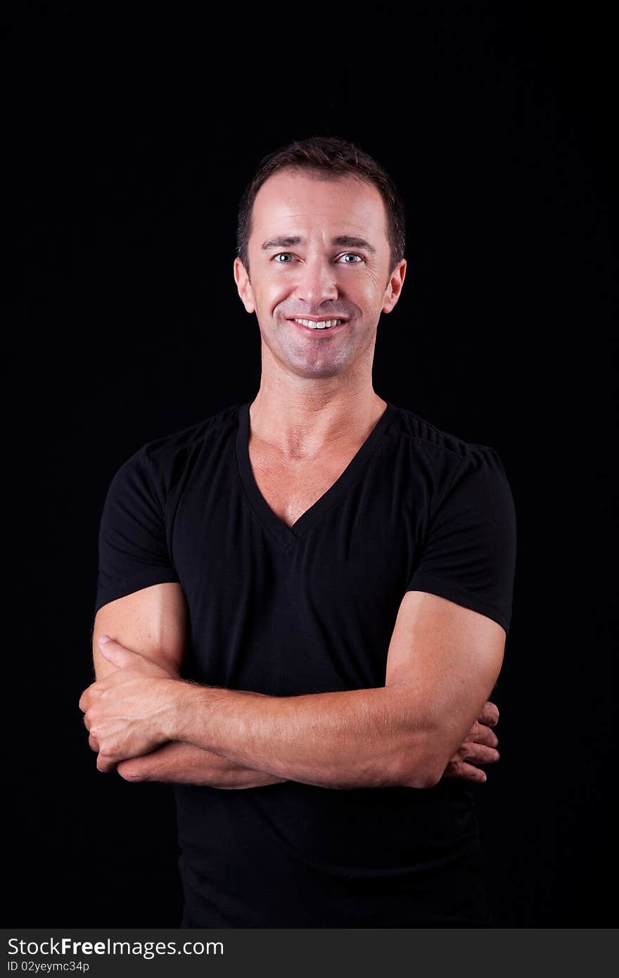 Portrait of a handsome middle-age man smiling, on black background. Studio shot