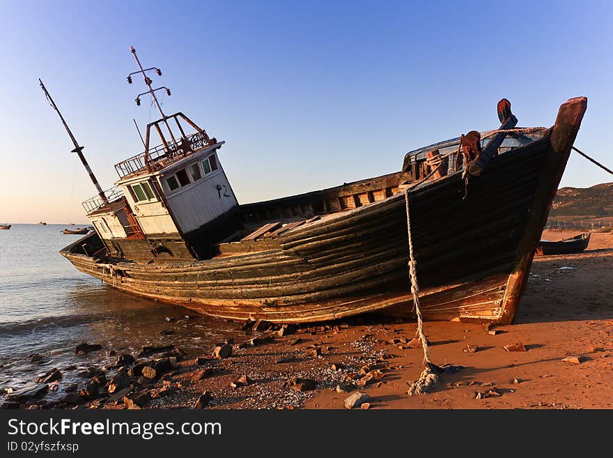 A fishing vessel lay at anchor in the bay