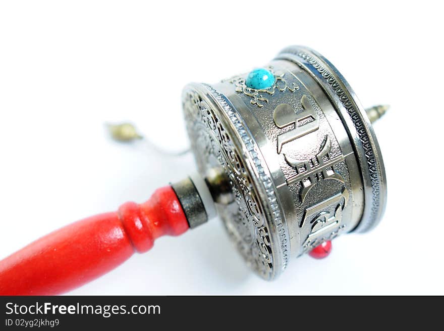 Close-up view of a Tibetan prayer wheel isolated on white background.