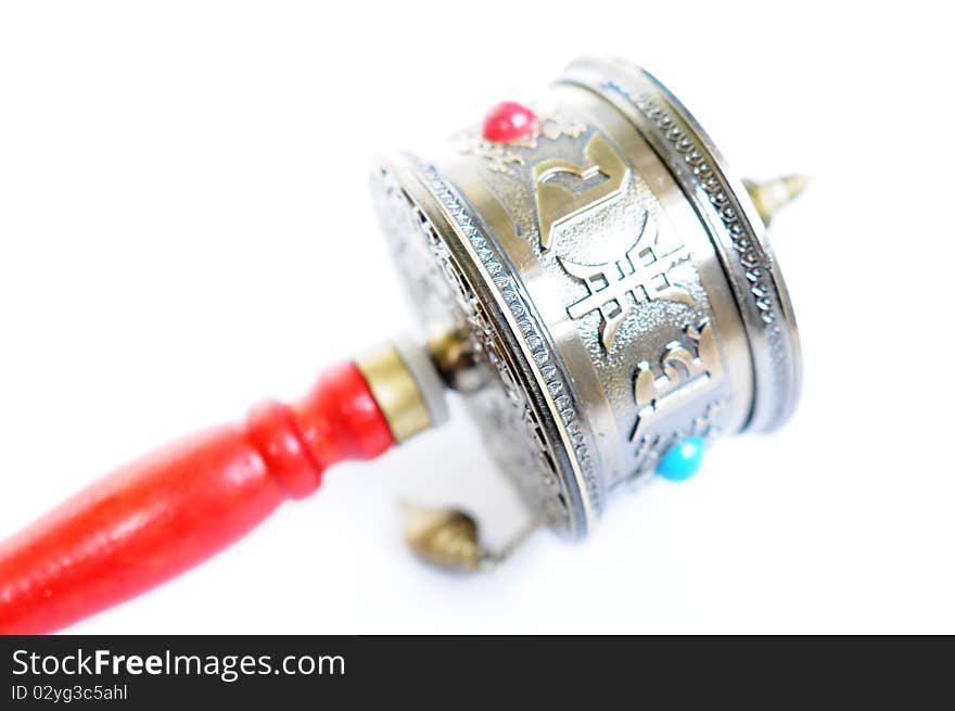 Close-up view of a Tibetan prayer wheel isolated on white background.