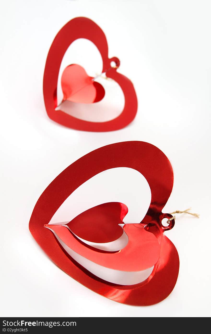 Two red shiny  hearts on white background