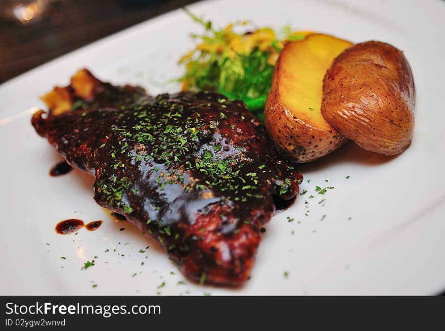 Plate of grilled dory fillet with black pepper sauce and baked potatoes. Plate of grilled dory fillet with black pepper sauce and baked potatoes