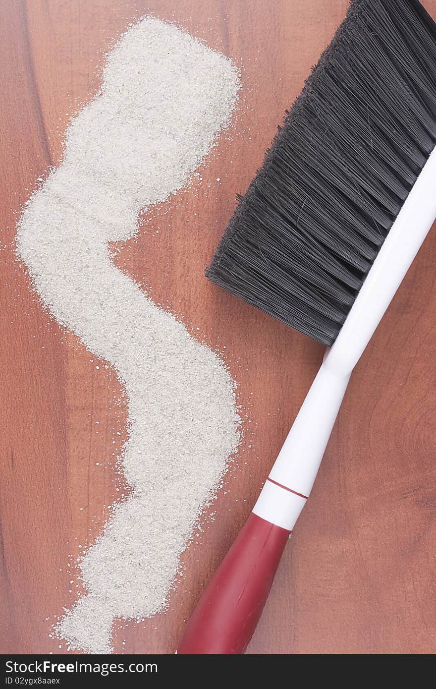 House cleaning, on a floor small sand simulating dust is scattered.