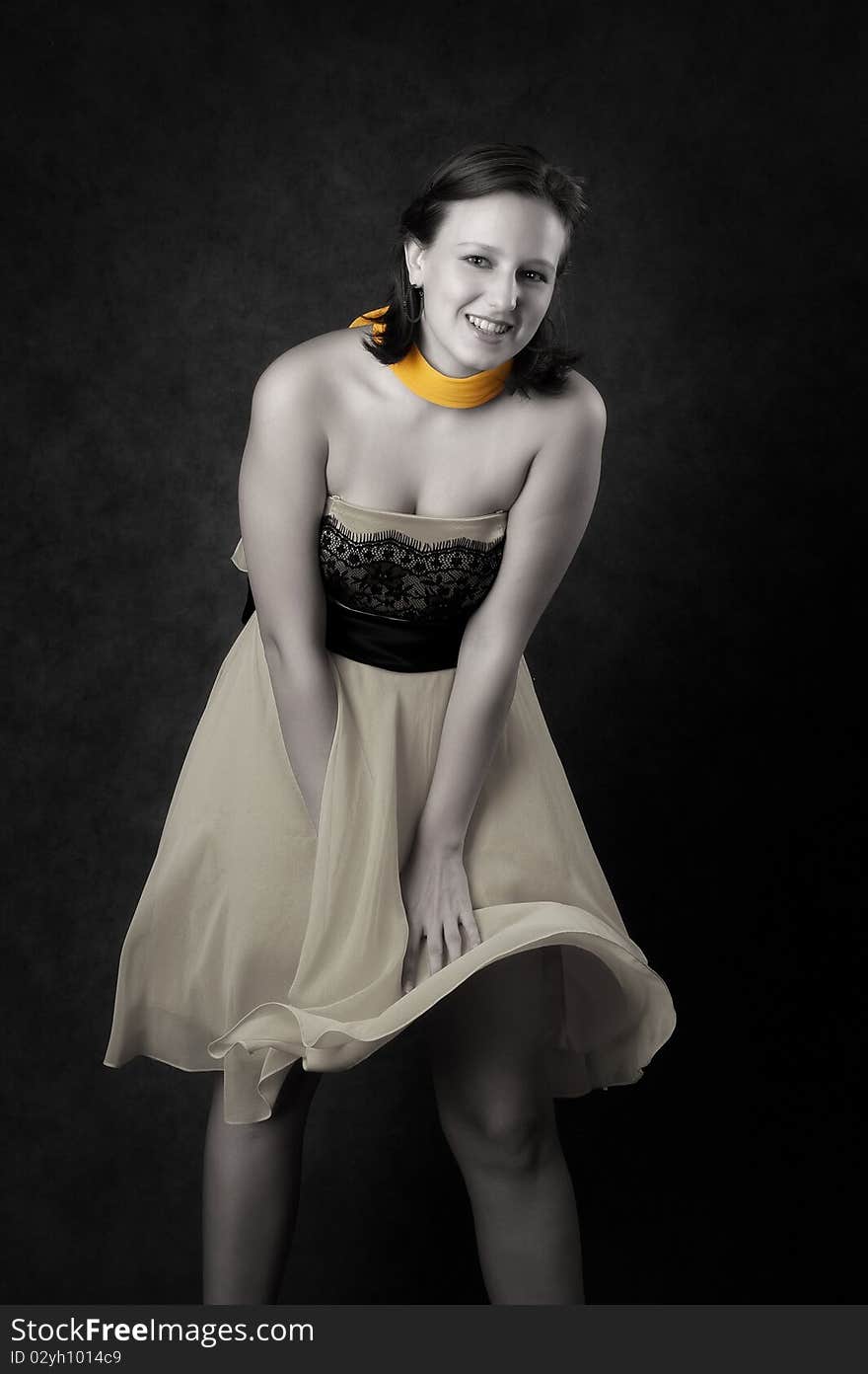 Young woman in a dress. Dark background