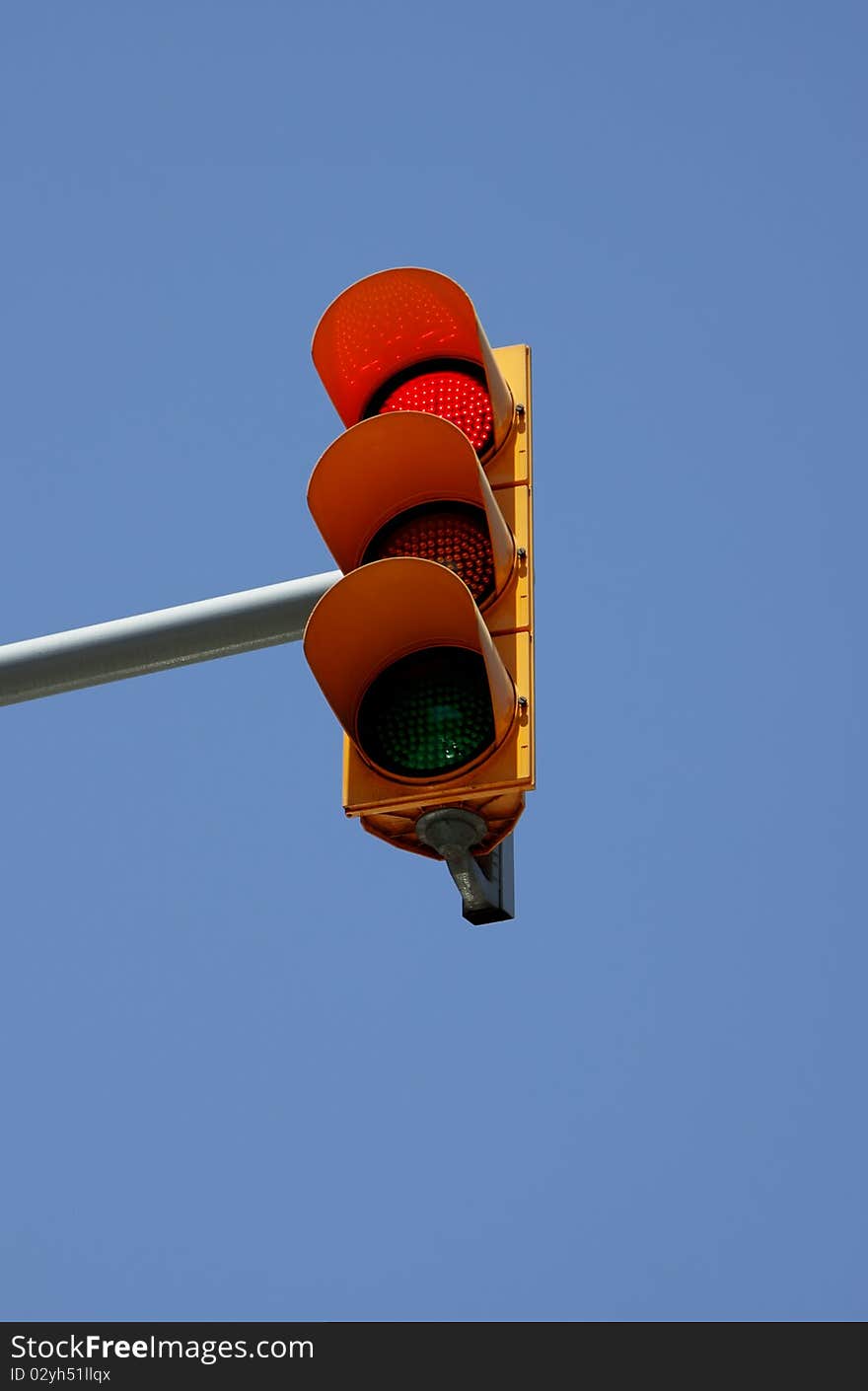 Red signal of a traffic light. Against the blue sky. Red signal of a traffic light. Against the blue sky.