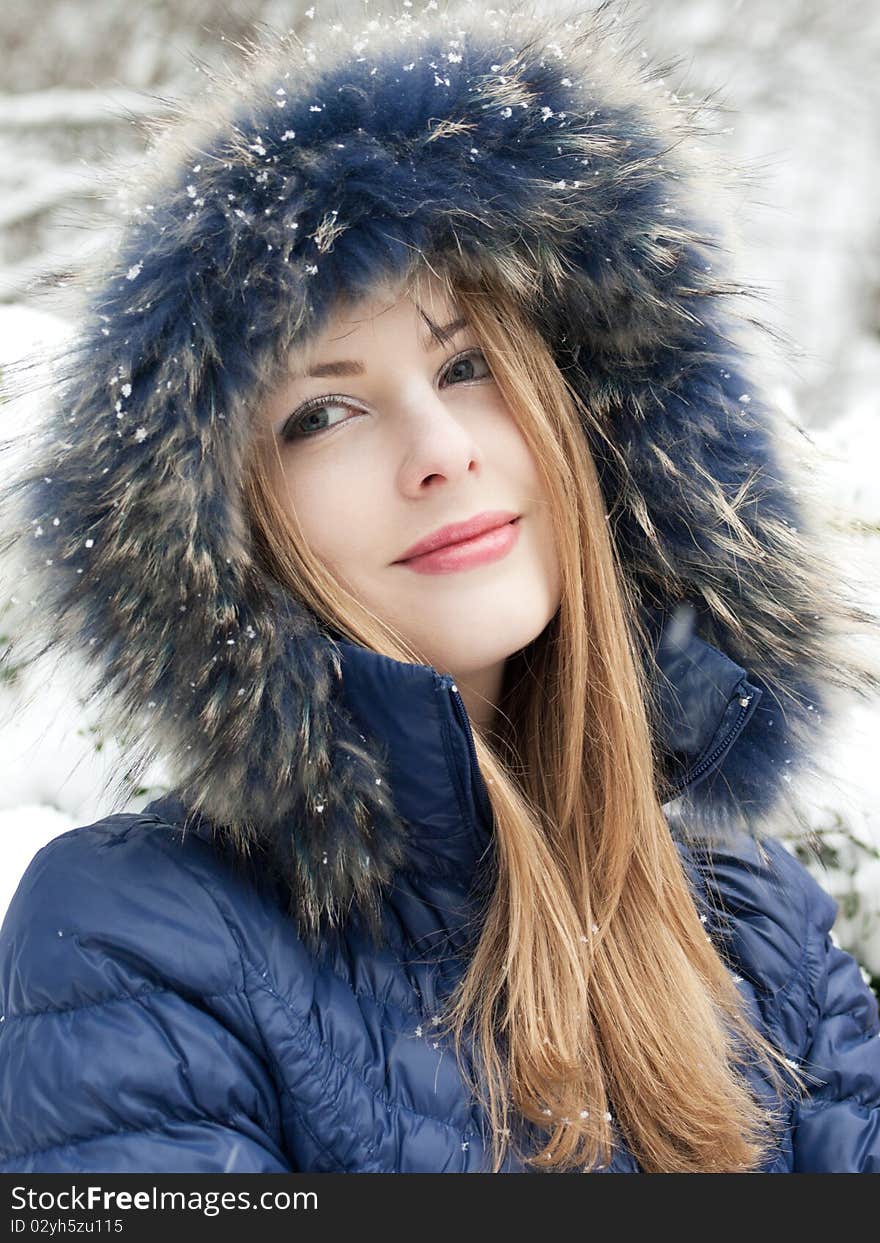 Smiling young woman in blue coat outdoors. Smiling young woman in blue coat outdoors