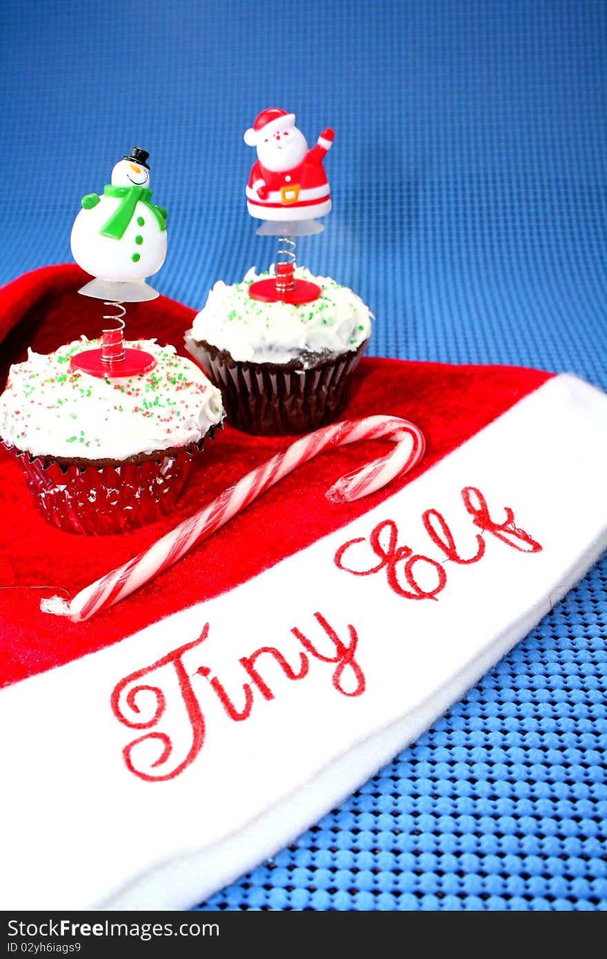 Santa hat with two cupcakes decorated for Christmas and candy cane. Santa hat with two cupcakes decorated for Christmas and candy cane