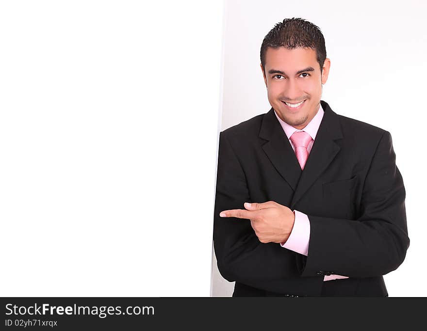 Young businessman in suit smiling and pointing copy space