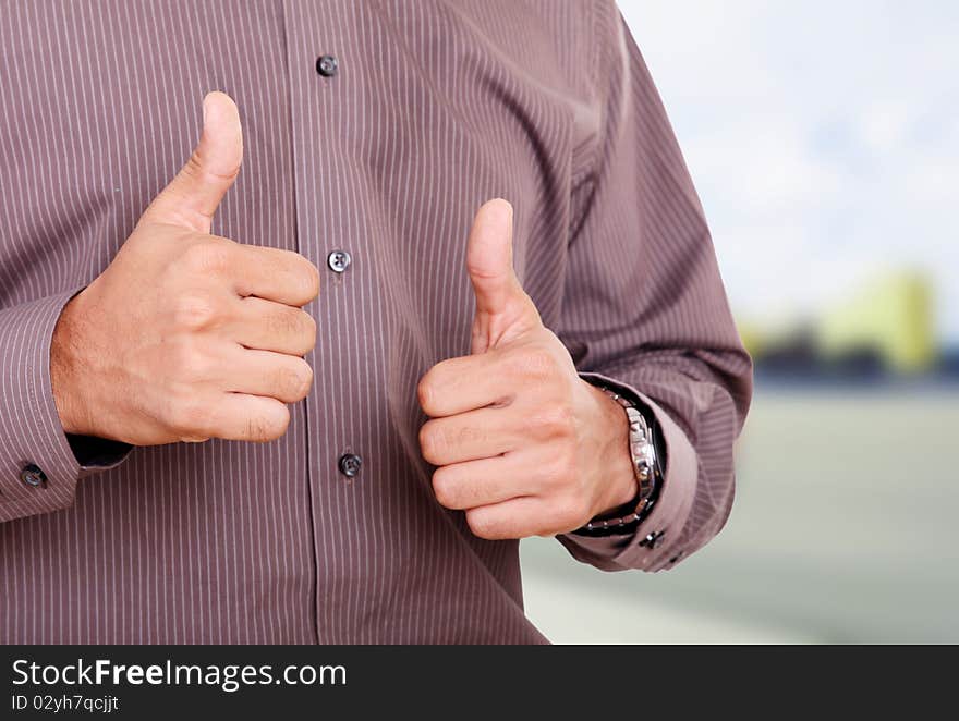 Young man expressing positivity with his hands, outdoor image