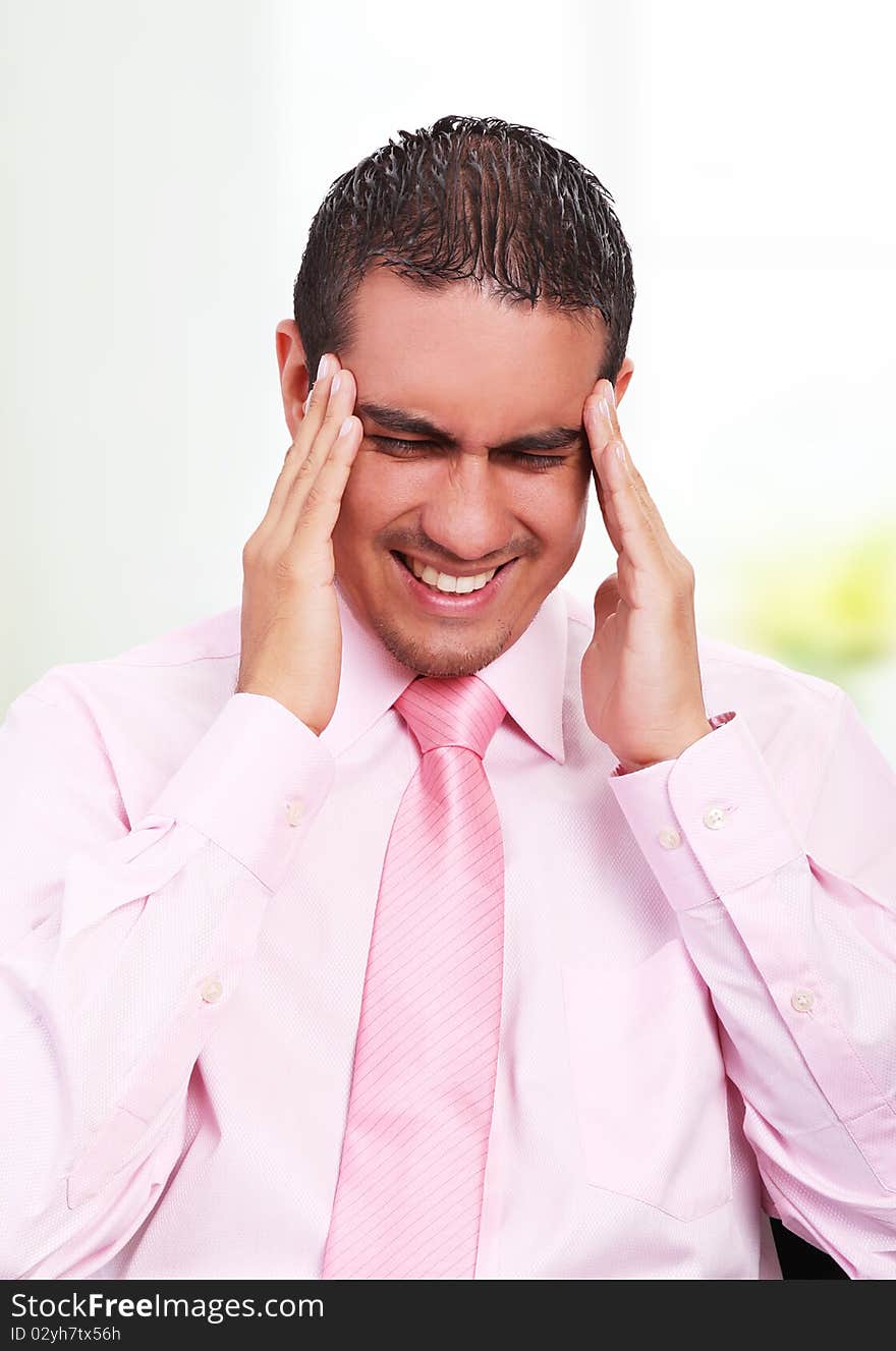 Young businessman with headache, expressing pain with his face