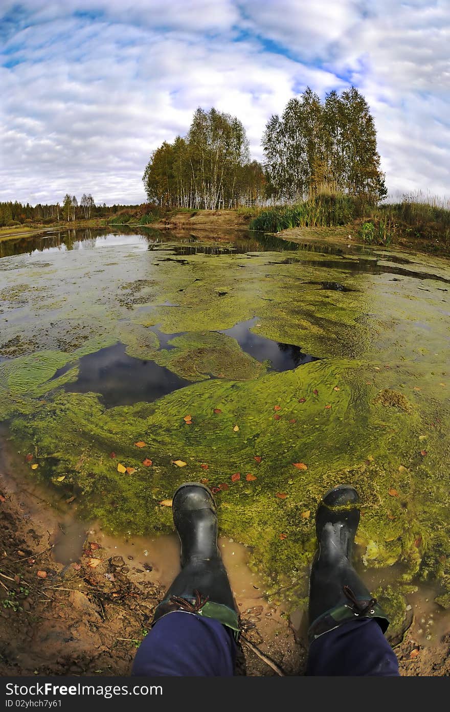 The fisherman sits near a swamp. Photo. The fisherman sits near a swamp. Photo