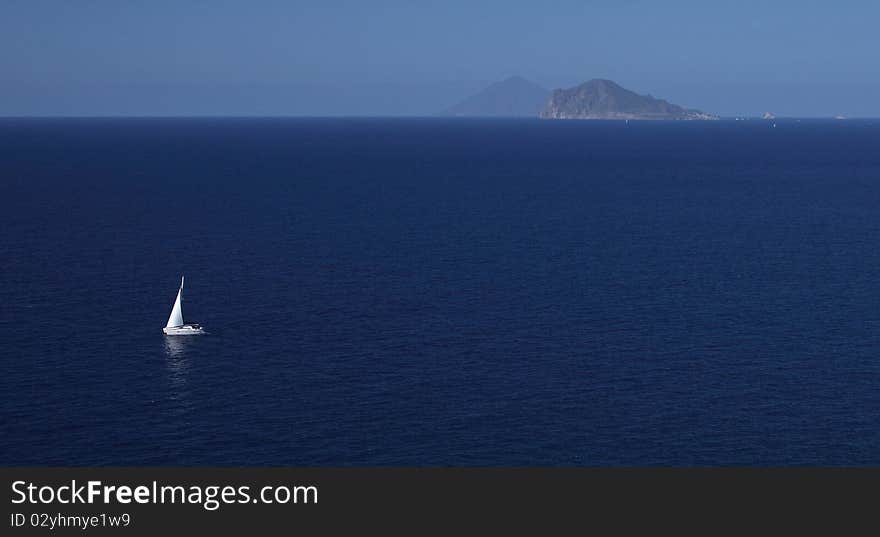 Yacht sailing among Eolian islands Lipari and Panarea. Stromboli in the background. Yacht sailing among Eolian islands Lipari and Panarea. Stromboli in the background.