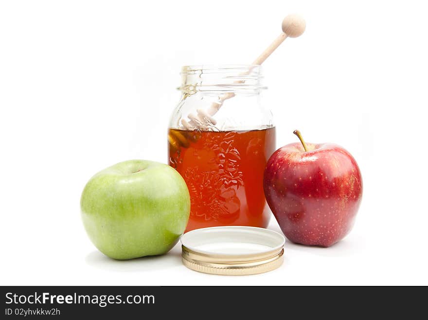 Pot with the fresh honey and tow apples on the white background