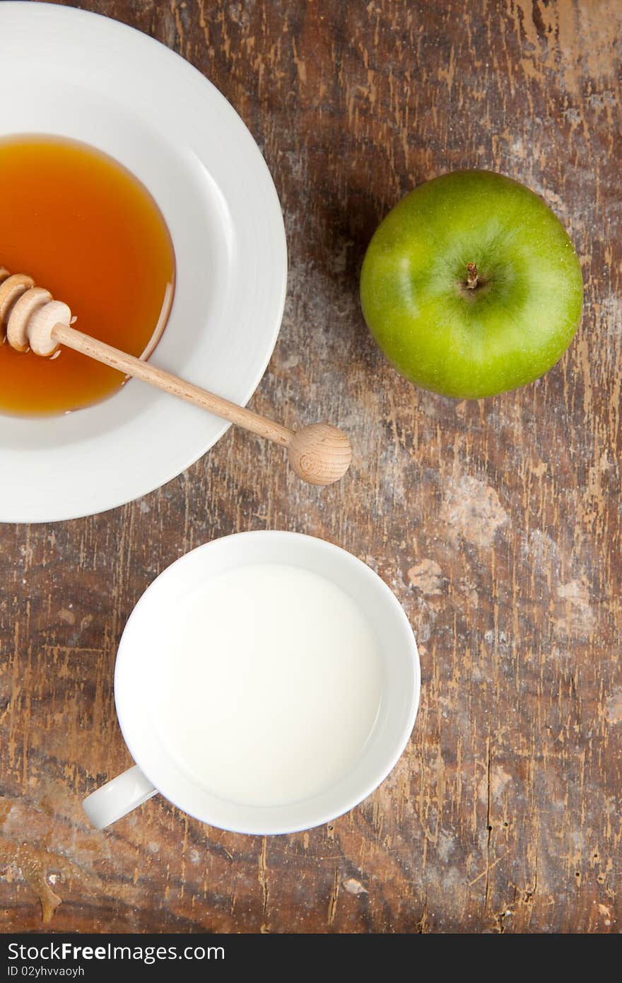 Breakfast with milk, honey and apple on the old wooden table