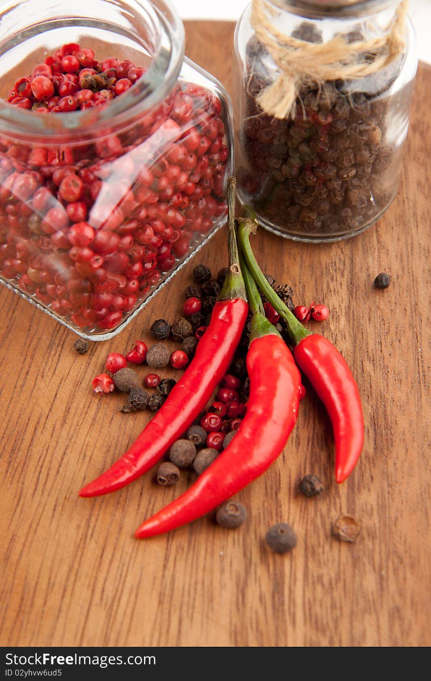 Red chili pepper and pepper's mix on the wooden desk