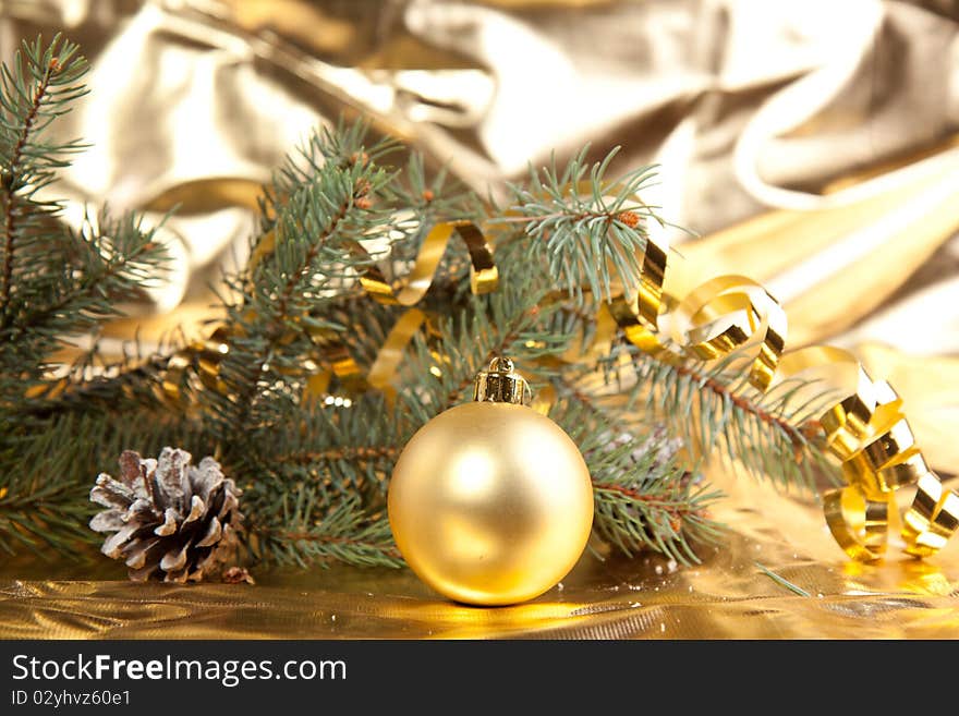 Golden christmas ball and cone with christmas tree on the gold background