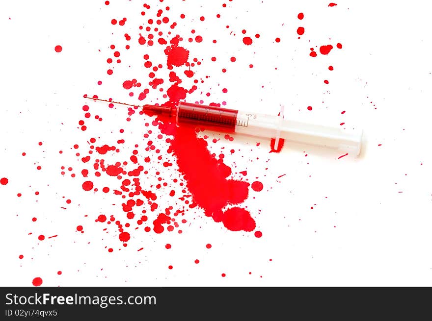 Syringe with a red liquid and stains