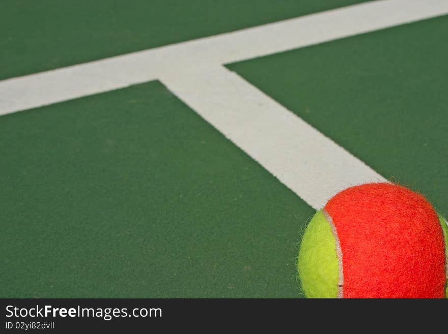 Yellow-red balls on a green tennis court. Yellow-red balls on a green tennis court