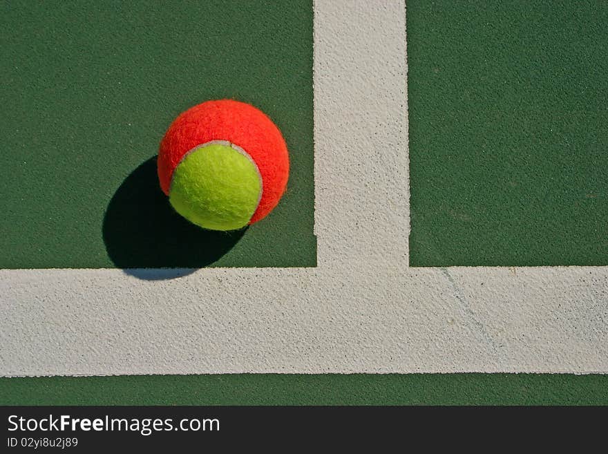 Yellow-red balls on a green tennis court. Yellow-red balls on a green tennis court