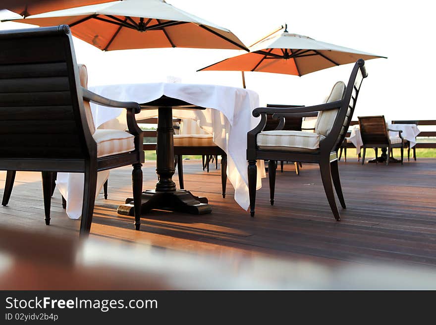 Table with white tablecloth and umbrellas outdoors. Table with white tablecloth and umbrellas outdoors