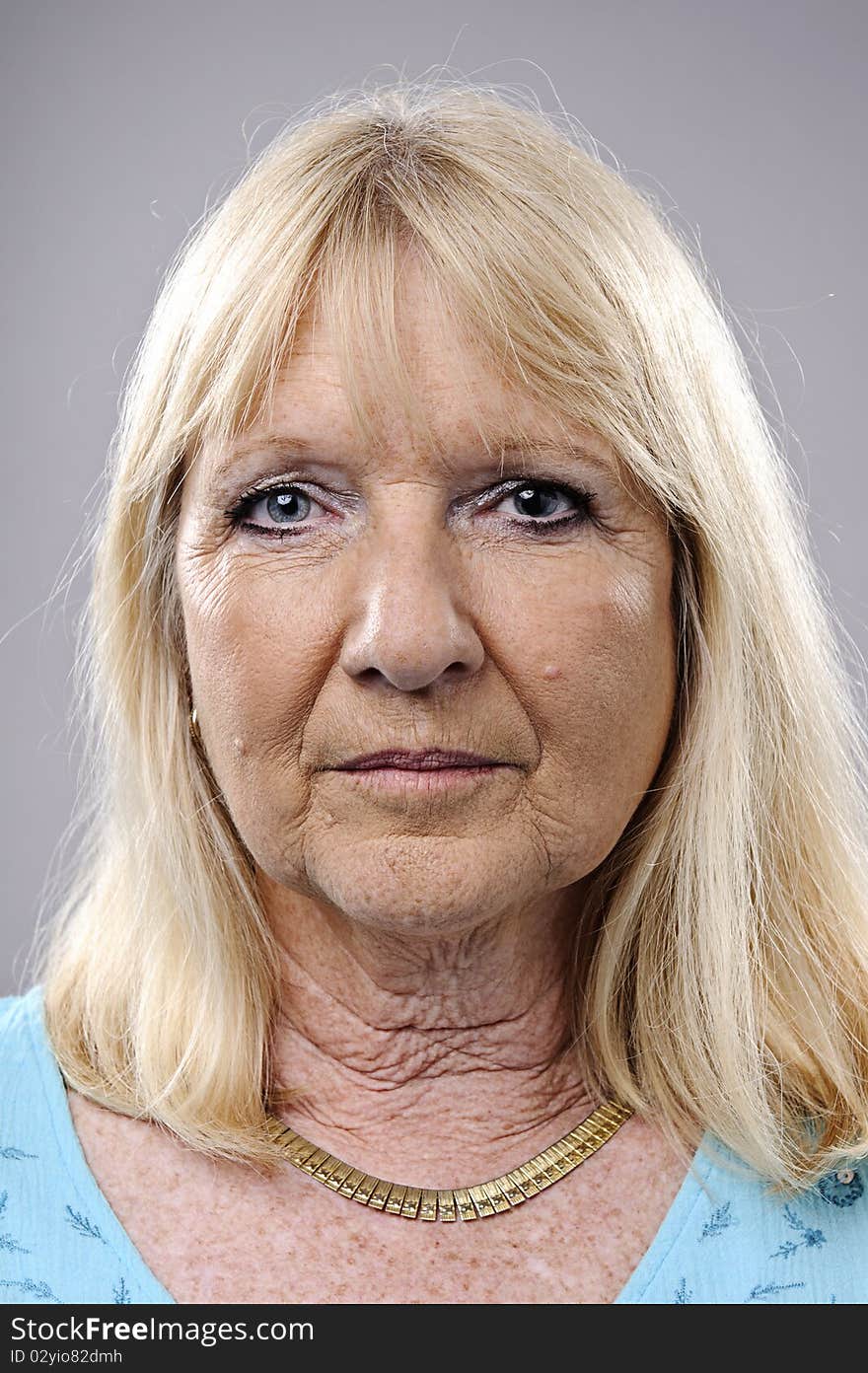 Wrinkled blonde woman poses for a portrait in studio. Wrinkled blonde woman poses for a portrait in studio